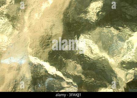 A warm golden textured glass surface with abstract patterns. Stock Photo
