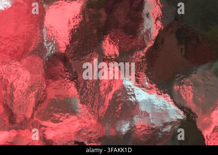 Vibrant red textured glass surface with abstract patterns. Stock Photo