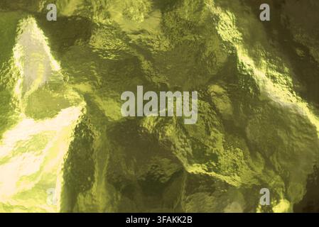 Bright green textured glass surface with abstract patterns. Stock Photo
