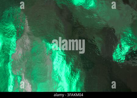 Bright green textured glass surface featuring abstract crystalline details. Stock Photo