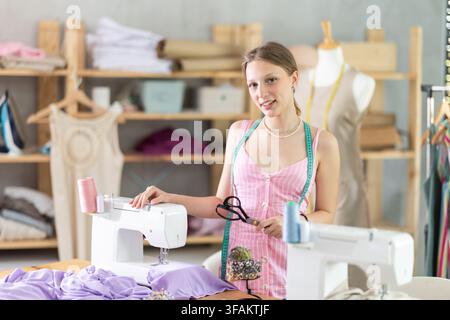 Young woman seamstress invites to the workshop Stock Photo