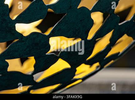 A close-up detail of a dark verdigris-patinated bronze outdoor sphere sculpture, Stock Photo