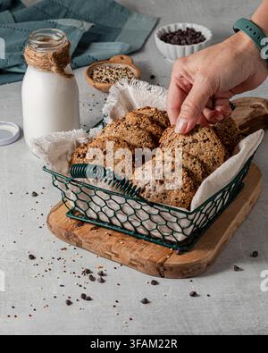 A hand reaching into a basket of delicious quinoa chocolate chip cookies. Stock Photo