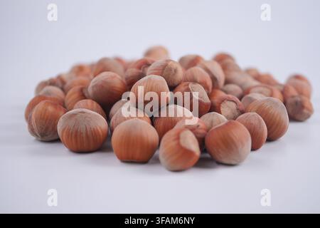 Hazelnuts placed on a white surface in a casual setting Stock Photo