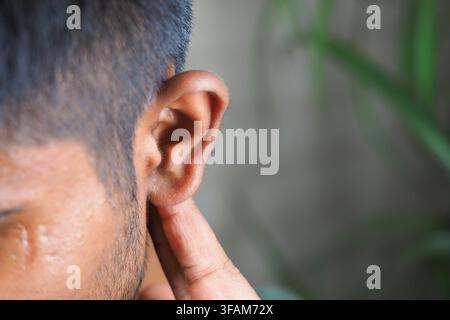 Young person touching their ear in a close-up view Stock Photo