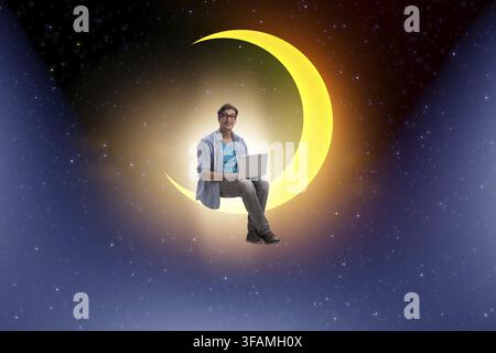 The student is working on a laptop on the crescent moon Stock Photo