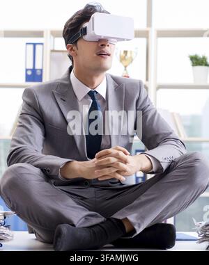 Businessman using VR virtual reality glasses in office Stock Photo