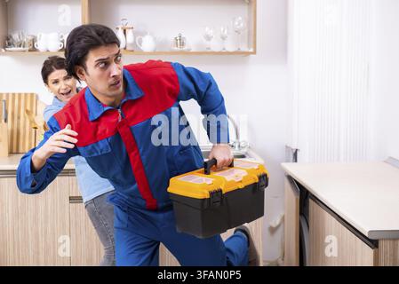 Young male mechanic repairs faucet Stock Photo
