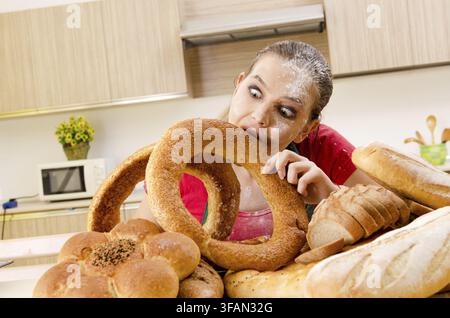 Young female baker working in the kitchen Stock Photo