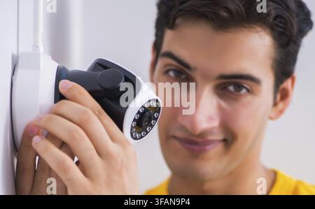 Contractor installs CCTV security cameras in office Stock Photo