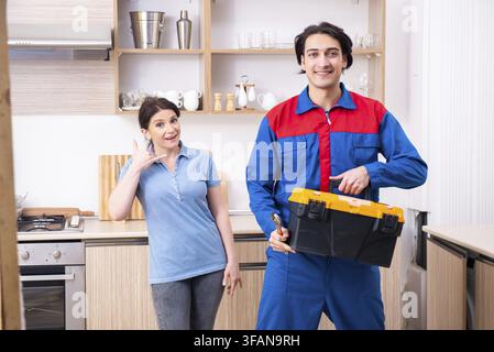 The young male mechanic repairs the faucet Stock Photo