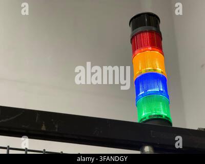A detailed photograph of a factory warning light featuring green, blue, yellow, and red stack lights used for machine status indicators, safety alerts Stock Photo
