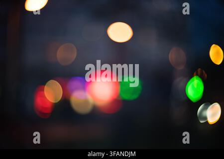 Abstract background image featuring colorful glowing bokeh lights against a dark night sky creating a soft dreamy visual effect with vibrant circular Stock Photo