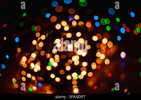 An abstract composition featuring vibrant colorful glowing bokeh lights scattered across a dark background creating a festive atmosphere. Stock Photo