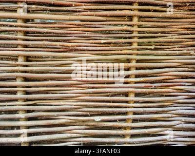 Close-up view of a traditional Ukrainian fence made from intertwined natural branches, showcasing its weathered texture and authentic craftsmanship Stock Photo
