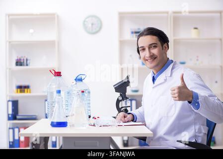 The young male chemist is experimenting in the laboratory Stock Photo