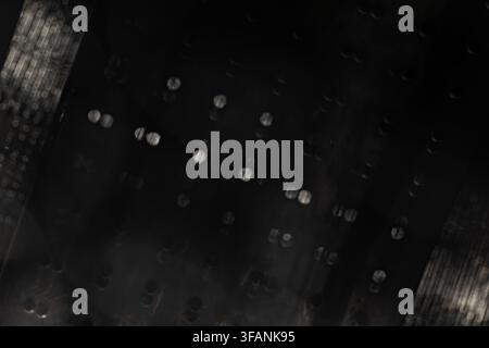 Dark abstract optical texture with scattered silver bokeh and blurred mesh edges for cinematic light overlay and background Stock Photo