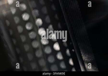 Defocused silver mesh lights with diagonal dark bands and soft geometric bokeh for abstract monochrome optical background Stock Photo
