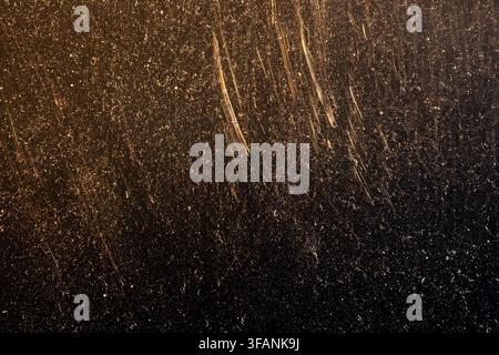 Warm golden film burn texture with dust and long vertical scratches fading into black for distressed vintage overlay Stock Photo