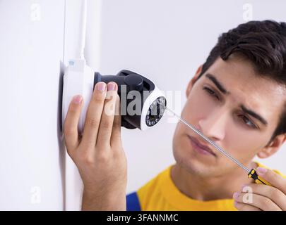 Contractor installs CCTV security cameras in office Stock Photo