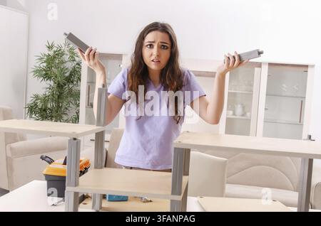 Young woman repairing chair at home Stock Photo