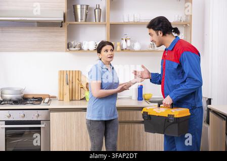Young male mechanic repairs faucet Stock Photo