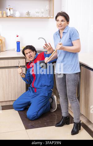 Young male mechanic repairs faucet Stock Photo