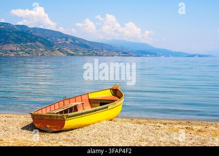 Wooden fishing rowing boat moored on the beach of Lake Ohrid - Pogradec, Albania Stock Photo