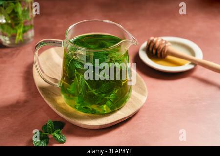 Fresh mint tea in a clear glass teapot, homemade herbal drink Stock Photo