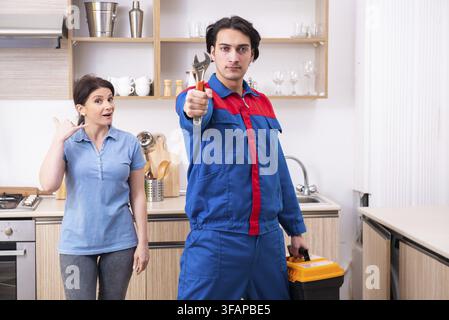 Young male mechanic repairs faucet Stock Photo