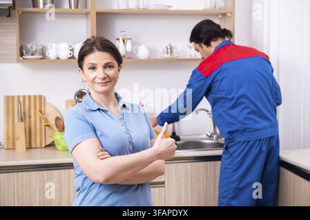 Young male mechanic repairs faucet Stock Photo