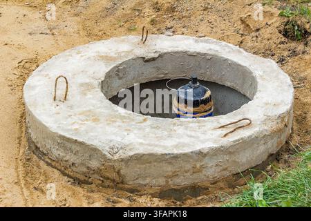 A submersible drainage pump is installed in the basement well. It is an automatic pump for pumping out water with a float switch. Stock Photo