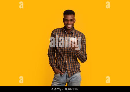 Portraif Of Handsome Young African American Guy With Smartphone In Hands Stock Photo