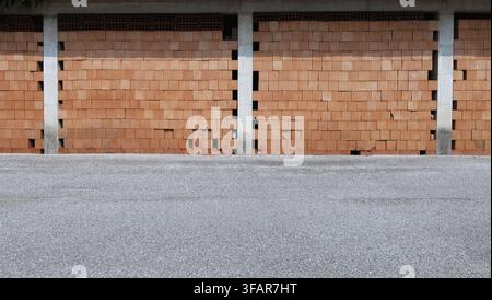 Wall at roadside made of stacked hollow bricks between concrete columns. Background for copy space. Stock Photo