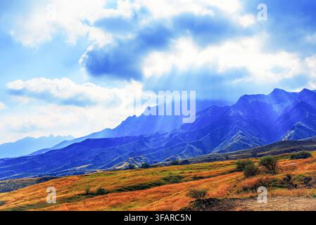 Sun-rays break through clouds illuminating autumn hills in Aso, Kumamoto Prefecture, Kyushu, Japan Stock Photo