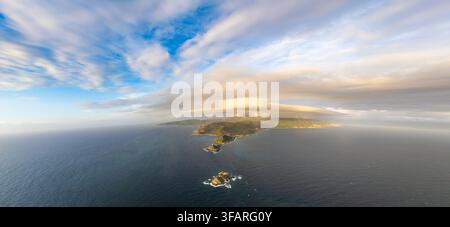 Aerial view of the island of Corsica surrounded by the Mediterranean Sea with a lenticular cloud formation over the mountains in France. Stock Photo