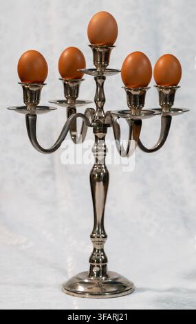 "Surrealism in the Kitchen: Candelabra and Eggs" The image displays a conceptual, surrealist fine art still-life photograph featuring five eggs Stock Photo