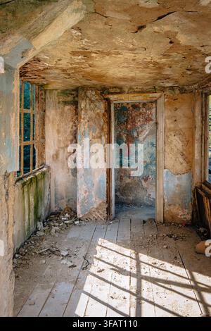 Sunlight casts geometric shadows across a decaying gallery inside Temur Maghradze Stadium in Chiatura, Georgia Stock Photo