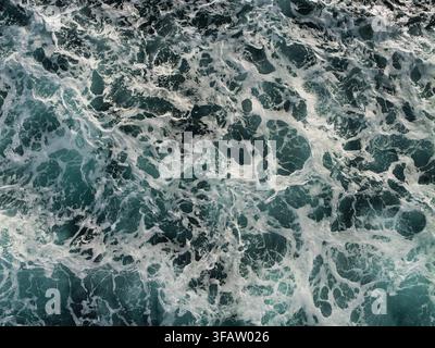 Foaming waves form an energetic abstract pattern across dark water in the North Sea, UK Stock Photo