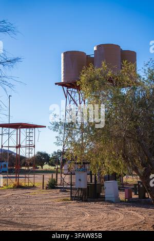 Water storage tanks on steel towers stand near trees in Namibia Stock Photo