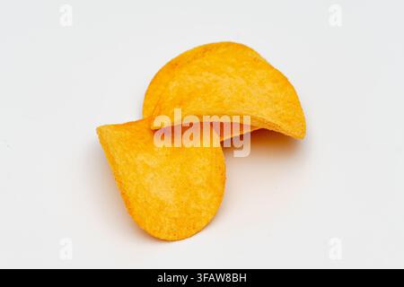 Two crispy potato chips are isolated on a white background in a close-up view. Stock Photo