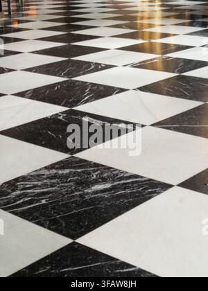 Marble floor tiles creating a diagonal checkerboard pattern with reflections Stock Photo