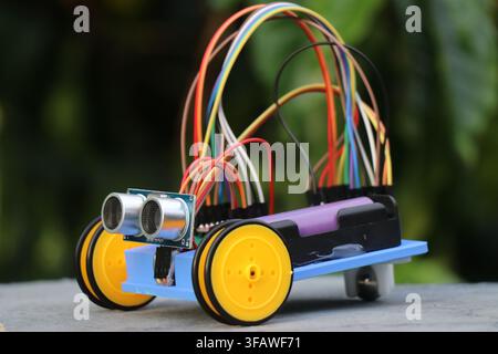 Programmable diy robotic car with obstacle sensor and small wheels powered by battery Stock Photo