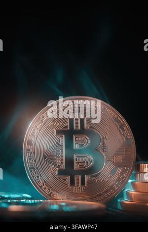 single physical Bitcoin coin against a dark background with green atmospheric light. Stock Photo