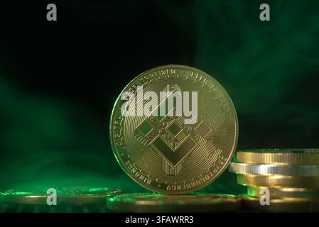 Close up of Binance crypto coin with abstract green smoke and lighting Stock Photo
