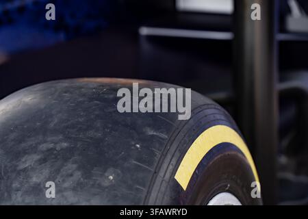 Close up of a formula racing slick tire featuring a distinct yellow stripe on the sidewall and smooth rubber compound surface texture Stock Photo