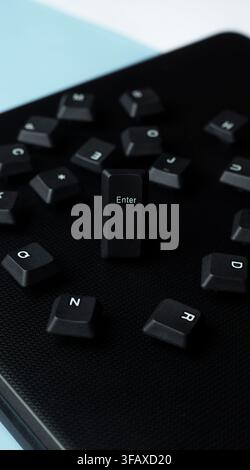 Scattered black keyboard keys with a focused Enter key on a dark laptop surface, representing input, access, submit, command, and digital action. Stock Photo