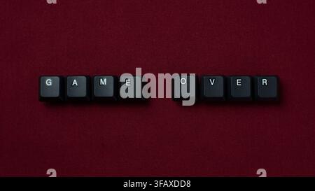 Game Over Failure Concept With Keyboard Keys On Red Background. representing failure, defeat, ending, gaming, and restart concept. Stock Photo