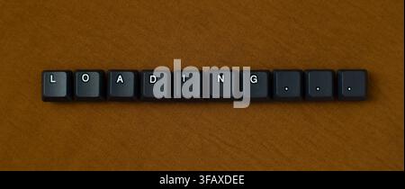Loading Progress Message With Keyboard Keys On Brown Background Stock Photo