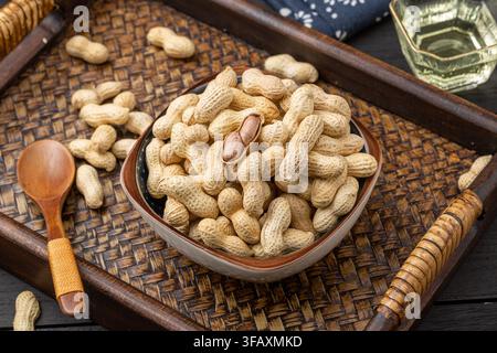 Roasted peanuts in shell served on blue dish Stock Photo